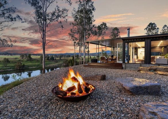 Sunset-filled ranch with fire pit in front and house just behind