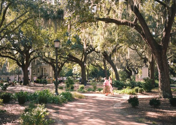 Two women walking on the square with live oaks