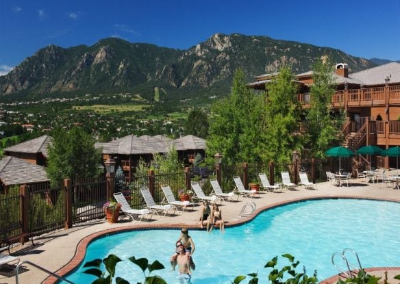 Mountains tower over a resort pool in Colorado