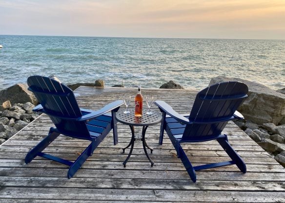 chairs on a lakefront deck at sunset